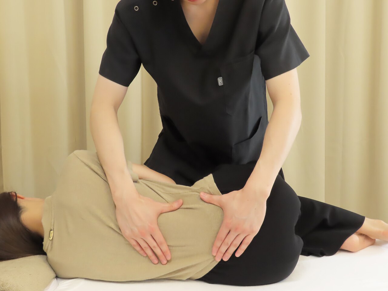 横向きの姿勢で肩まわりの施術を受ける様子